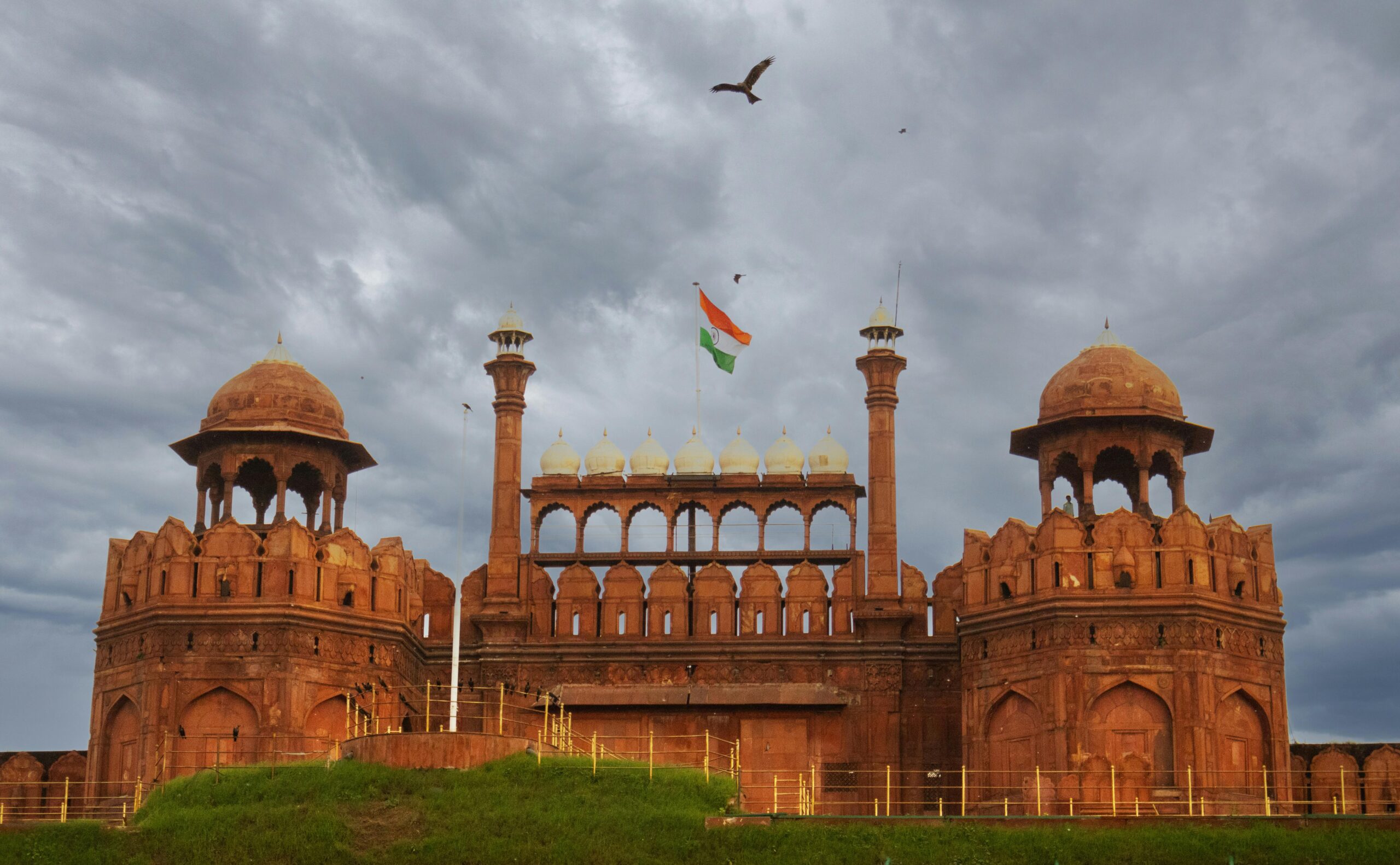 Stormy sky over the iconic Red Fort in New Delhi with the Indian flag flying high.